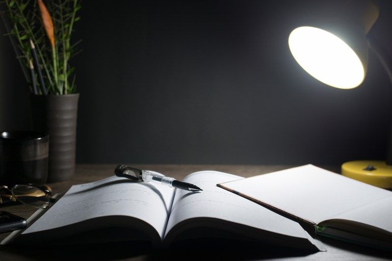 Reading table at night, Open books on the table, Close-up the pen tip, Copy-space.; Shutterstock ID 1446200666; purchase_order: aj; job: ; client: ; other: