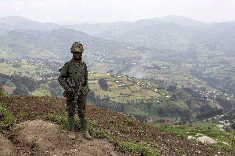 A M23 soldier stands in the Masisi territory on March 5, 2025. Ravaged by conflict for 30 years, eastern DRC is believed to hold between 60% and 80% of the world's reserves of coltan, an essential mineral for manufacturing electronic equipment. UN experts say that the Rubaya deposits bring in around $800,000 per month to the M23, thanks to a tax of $7 per kilogram levied on the production and trade of coltan. (Photo by Camille Laffont / AFP)
