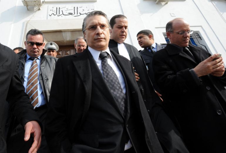The director of the Tunisian private TV channel Nessma television, Nabil Karoui (C), leaves the courthouse on January 23, 2012 in Tunis after the postponment of his trial. Karoui is charged with
