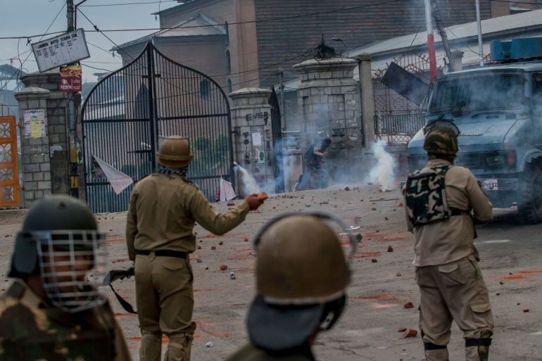 A masked Kashmiri protester runs for cover amid tear gas smoke fired by Indian policemen during a protest in Srinagar, Indian controlled Kashmir, Friday, May 26, 2017. Government forces fired tear gas and pellets on Kashmiris protesting against the award of a medal to an Indian army officer who tied a Kashmiri to the front of his vehicle as human shield against stone throwing protestors. (AP Photo/Dar Yasin)