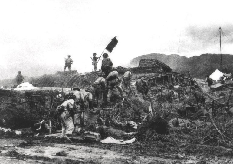 This picture taken 07 May 1954 shows a Vietnamese soldier waving a flag atop a French PC as others assault the area at the Dien Bien Phu battlefield. Vietnam will mark 13 March 2004 the 50th anniversary of the start of the siege of Dien Bien Phu, the epic battle that precipitated the collapse of French colonial rule in Indochina. The fighting began March 13, 1954, and 56 days later, 07 May, shell-shocked survivors of the French garnison hoisted the white flag to signal the end to one of the greatest battles of the 20th century. EDITOR'S NOTE: THE VAST MAJORITY OF VIETNAMESE PHOTOS OF THE BATTLE ARE RECONSTRUCTIONS DONE FOR THE PURPOSE OF PROPAGANDA. MOST OF THEM WERE TAKEN JUST HOURS AFTER THE ACTUAL EVENTS DEPICTED. AFP PHOTO/VNA/FILES (Photo by AFP / VNA FILES / AFP)