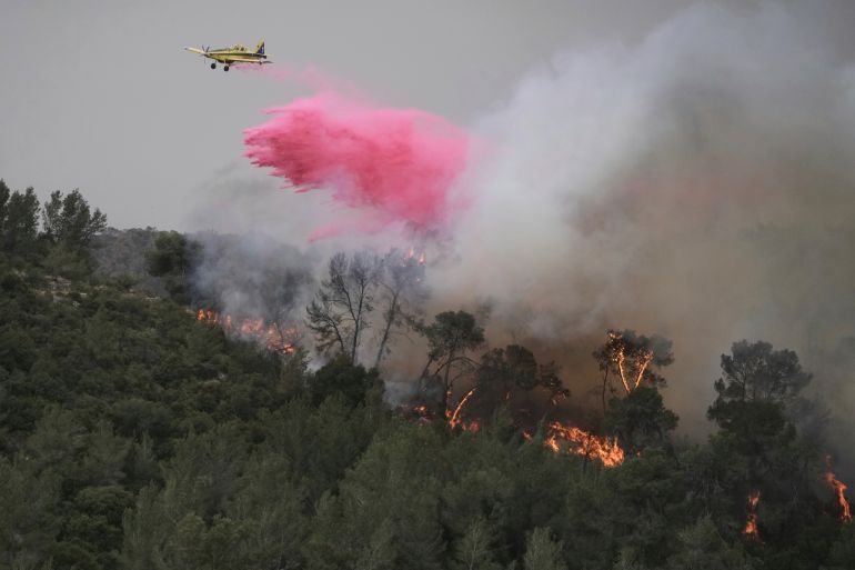 A plane uses a fire retardant to extinguish a fire burning in a forest near Jerusalem, Wednesday, April 30, 2025. (AP Photo/Mahmoud Illean)