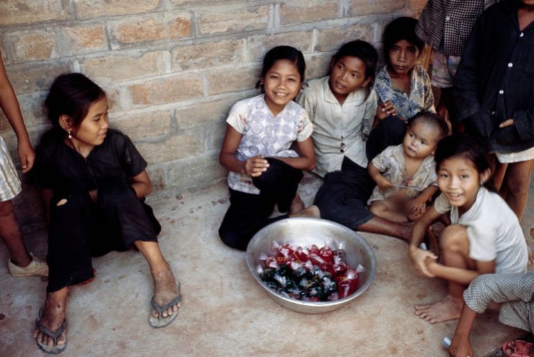 Vietnamese children seated next to a bowl of sweets outside a distribution centre in Bien Hoa refugee camp, Lai Thieu, July 27th 1968. (Photo by UPI/Bettmann Archive/Getty Images)
