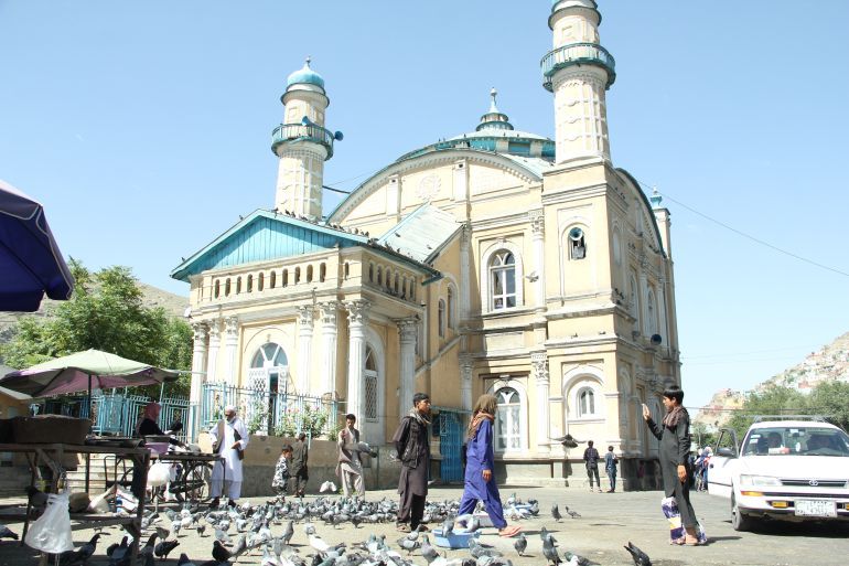 KABUL, AFGHANISTAN - 22 June 2018: shah do shamsheera mosque which is also known as the king with two swords, located near Kabul river, the mosque was built in 1920s. the pigeons are always there to attract people, KABUL, AFGHANISTAN - 22 June 2018