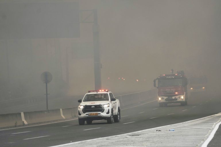 Israeli fire department drives through smoke from a burning fire on the freeway near Jerusalem, Wednesday, April 30, 2025. (AP Photo/Mahmoud Illean)