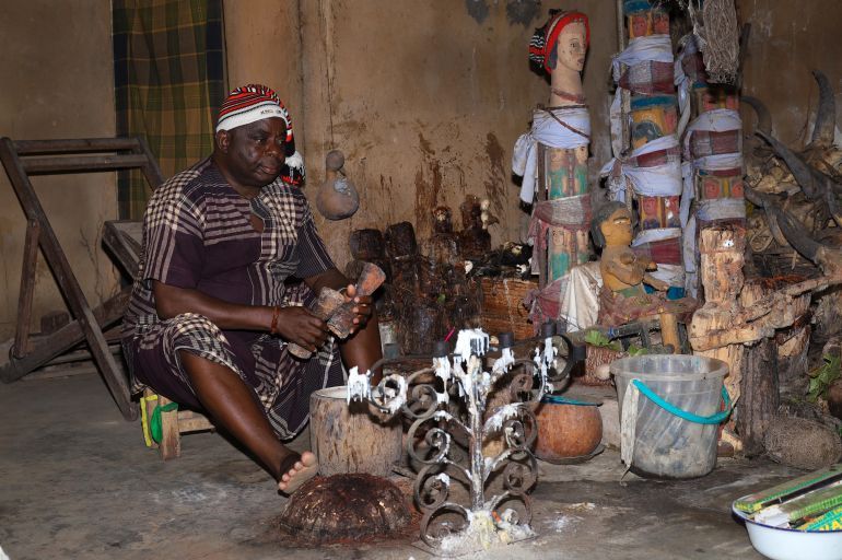 Nwaohia in his shrine surrounded by effigies, offerings and ritual items [Chibuike Nwachukwu/Al Jazeera]