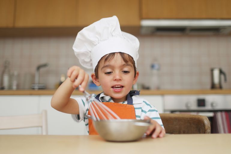 A 4 year old boy disguised as a cook - stock photo