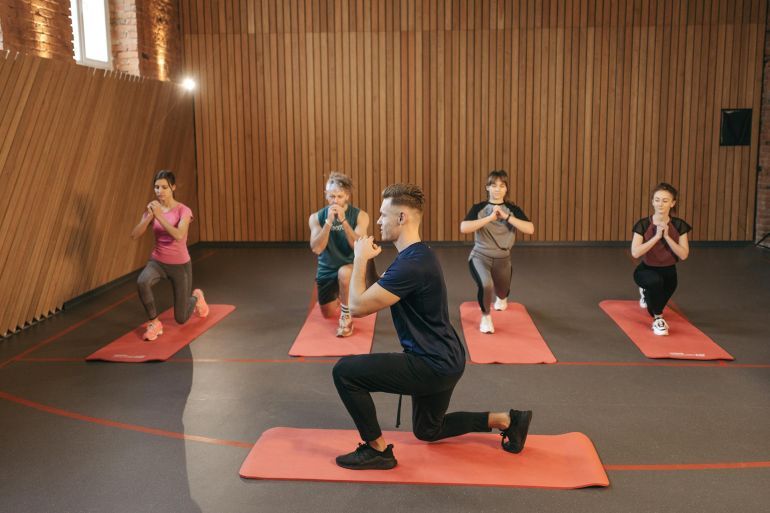 Group of People Stretching in Yoga Studio