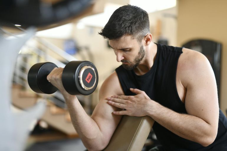 Man In Black Tank Top Holding Black Dumbbell