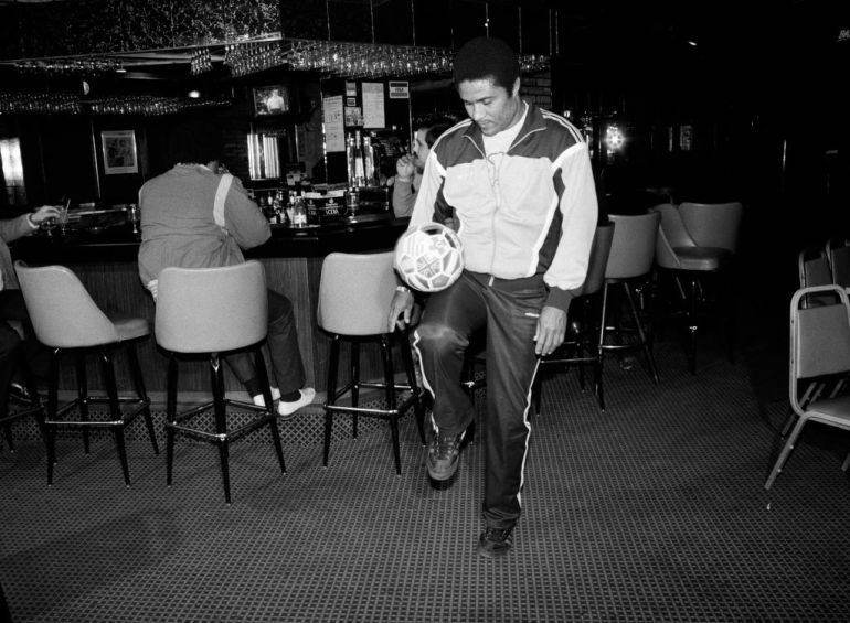 View of Portuguese soccer player Eusebio (born Eusebio da Silva Ferreira, 1942 - 2014) as he bounces a soccer ball on his knee in the Sport Club Portugues in the Ironbound neighborhood, Newark, New Jersey, February 21, 1987. (Photo by Rita Barros/Getty Images)