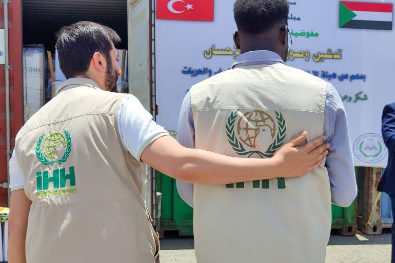 إثنين من العاملين يرتديان شعار هيئة الإغاثة التركية