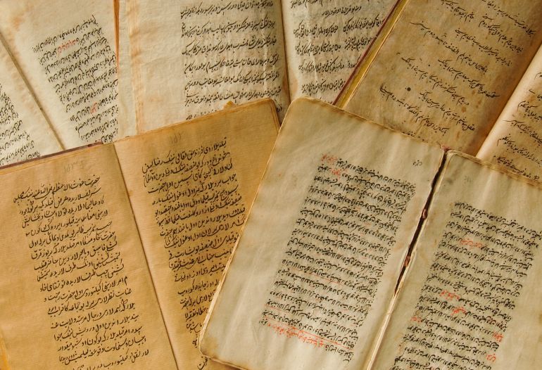 Tashkent, Uzbekistan - August 10, 2009: Stack of open ancient books in Arabic. Old Arabic manuscripts and texts. Top view