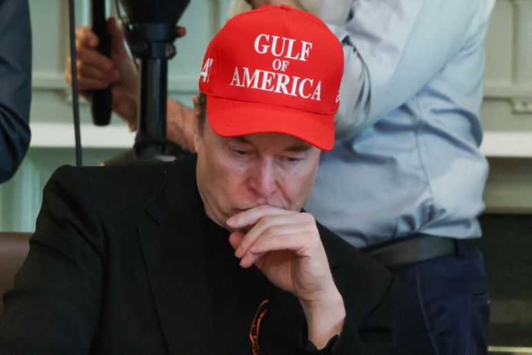 Tesla CEO Elon Musk wears a cap with the words