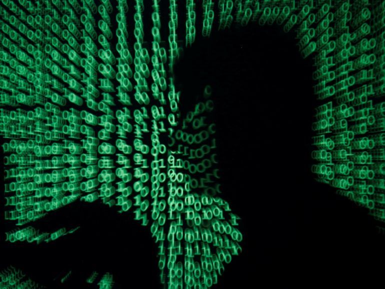 A man holds a laptop computer as cyber code is projected on him in this illustration picture taken on May 13, 2017. Capitalizing on spying tools believed to have been developed by the U.S. National Security Agency, hackers staged a cyber assault with a self-spreading malware that has infected tens of thousands of computers in nearly 100 countries. REUTERS/Kacper Pempel/Illustration