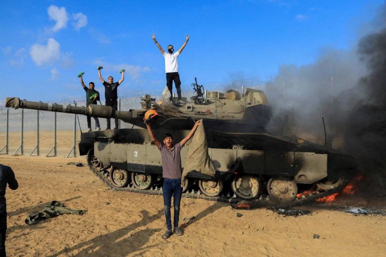 فلسطينيون يحتفلون باحتراق مركبة عسكرية إسرائيلية خلال هجمات السابع من أكتوبر