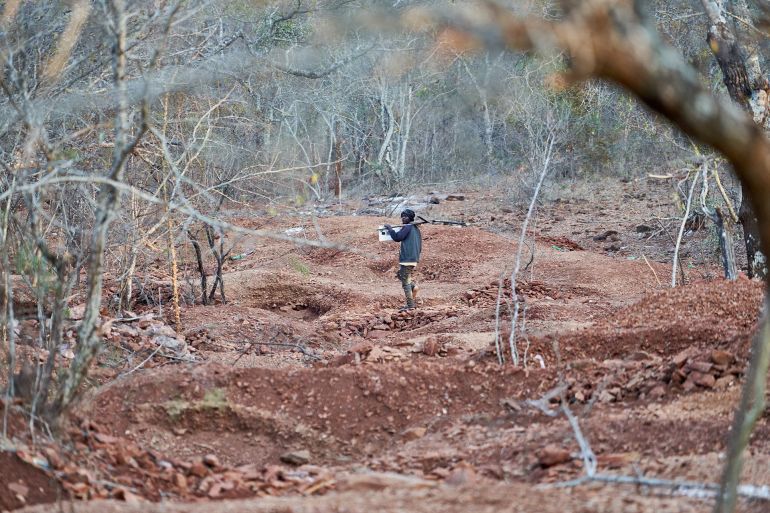 An artisanal gold miner walks towards a trench at a gold mining site in Zvishavane on August 22, 2023. (Photo by Zinyange AUNTONY / AFP)