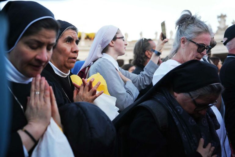 Nuns listen to newly elected Pope Robert Francis Prevost, Pope Leo XIV, address the crowd from the main central loggia balcony of the St Peter's Basilica for the first time, after the cardinals ended the conclave, in The Vatican, on May 8, 2025.