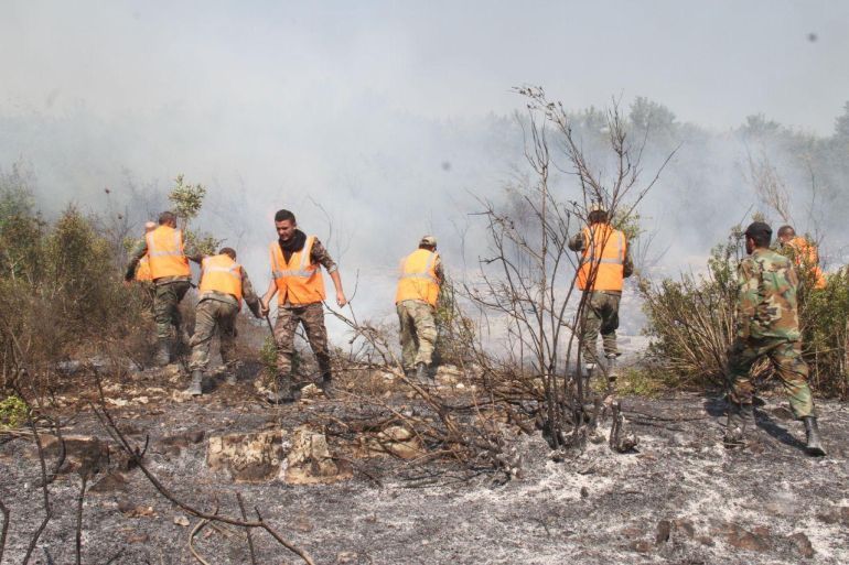 Firefighters work to put out a forest fire in Safita, Syria in this handout released by SANA on October 10, 2020. SANA/Handout via REUTERS ATTENTION EDITORS - THIS IMAGE WAS PROVIDED BY A THIRD PARTY. REUTERS IS UNABLE TO INDEPENDENTLY VERIFY THIS IMAGE.