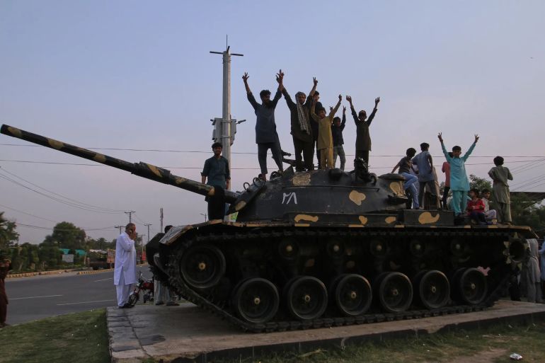Pakistani people flashing victory signs stand over a tank as they celebrate after the ceasefire between Pakistan and India, in Multan on May 10, 2025. Pakistan and India agreed to a full and immediate ceasefire on May 10 after days of deadly jet fighter, missile, drone and artillery attacks, the news surprisingly announced by US President Donald, who congratulated them on using