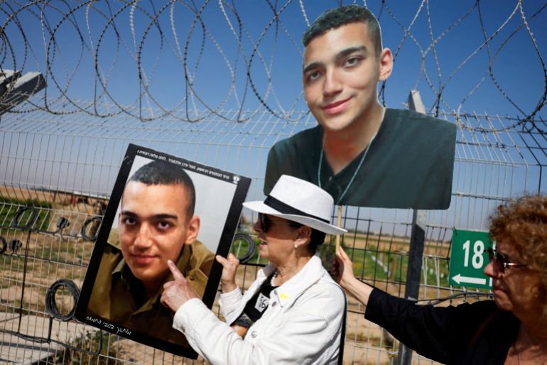 Varda Ben Baruch, grandmother of hostage Edan Alexander, points at the portrait of Edan, as family members and supporters of hostages who were kidnapped during the deadly October 7 attack, stand near the kibbutz defence on the day they use giant loudspeakers to call their captive loved ones over the border between Israel and Gaza, at Kibbutz Nir Oz, in southern Israel, April 20, 2025. REUTERS/Amir Cohen TPX IMAGES OF THE DAY