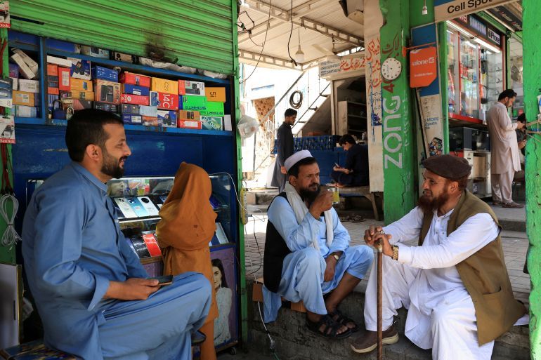 People sit outside a shop following the ceasefire announcement between India and Pakistan, in Islamabad, Pakistan, May 12, 2025. REUTERS/Akhtar Soomro