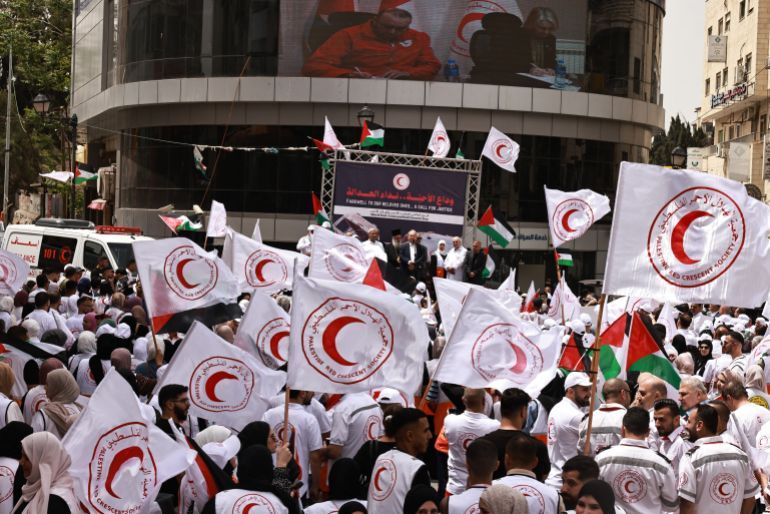 Palestinian Red Crescent crews hold a rally on World Red Cross and Red Crescent Day in Ramallah city in the occupied West Bank on May 12, 2025, to call for the protection of medical personnel and humanitarian workers in Gaza. (Photo by Zain JAAFAR / AFP)