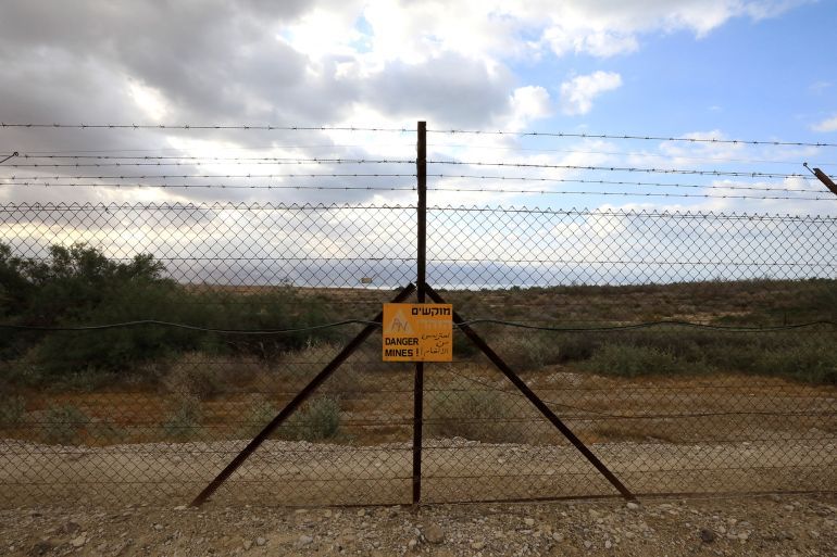 A sign hangs on a fence blocking the access to a minefield, south of the West Bank city of Jericho along the Dead Sea, near the border with Jordan, on April 26, 2020. The anti-personnel and anti-tank mines were planted by Israeli military battalions after the 1967 war as part of a new defence line. (Photo by Emmanuel DUNAND / AFP)