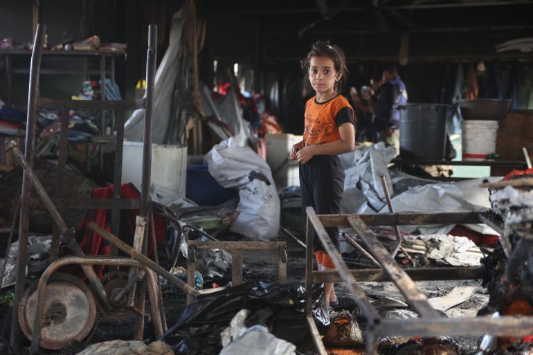A Palestinian girl looks for salvageable items amid the debris after an Israeli airstrike hit the Mussa bin Nusseir UNRWA school, serving as a shelter for people who left their homes in the besieged Palestinian territory, in Gaza City's Daraj district on May 20, 2025.
