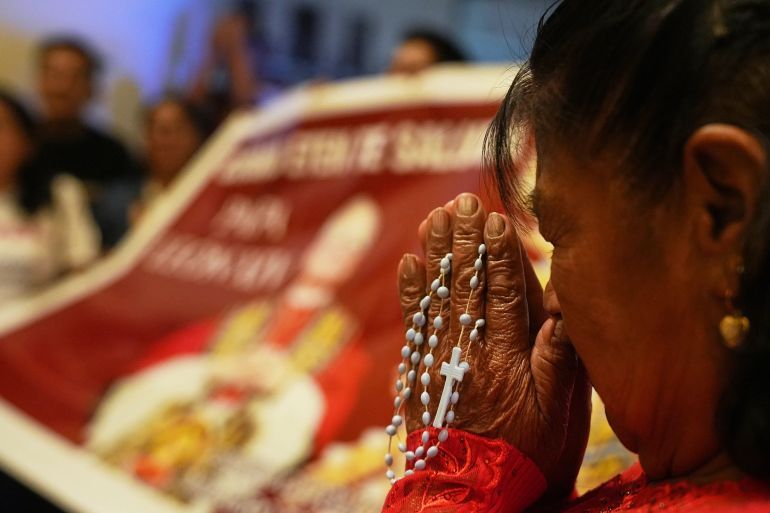 A parishioner prays in front of a banner of Pope Leo XIV during Mass at the Santa Maria Cathedral in Chiclayo, Peru, on May 8 [Guadalupe Pardo/AP Photo]