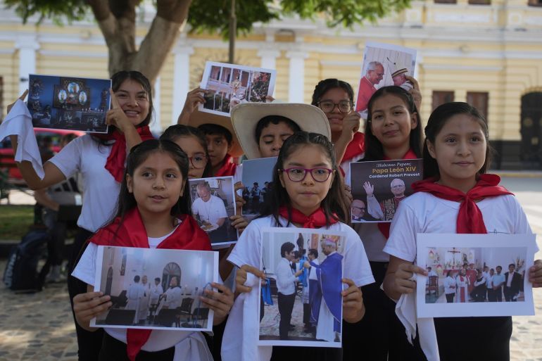 Members of a children’s choir display photos of newly elected Pope Leo XIV on May 9 [Guadalupe Pardo/AP Photo]