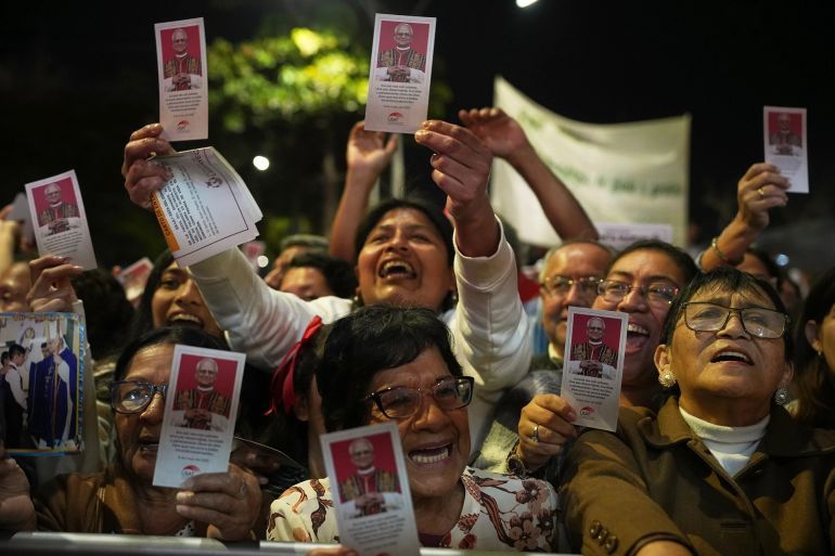 Residents in Chiclayo, Peru, hold up the picture of Pope Leo XIV during a mass in his honour on May 10 [Guadalupe Pardo/AP Photo]