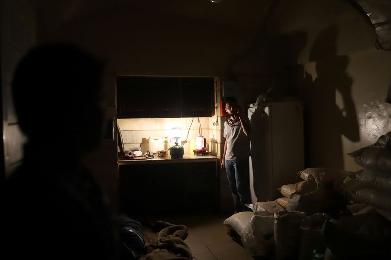 An Iranian shopkeeper talks on the phone in his shop while electricity is cut off due to energy savings in Tehran Bazaar, Iran, July 5, 2021. Picture taken July 5, 2021. Majid Asgaripour/WANA (West Asia News Agency) via REUTERS ATTENTION EDITORS - THIS IMAGE HAS BEEN SUPPLIED BY A THIRD PARTY.