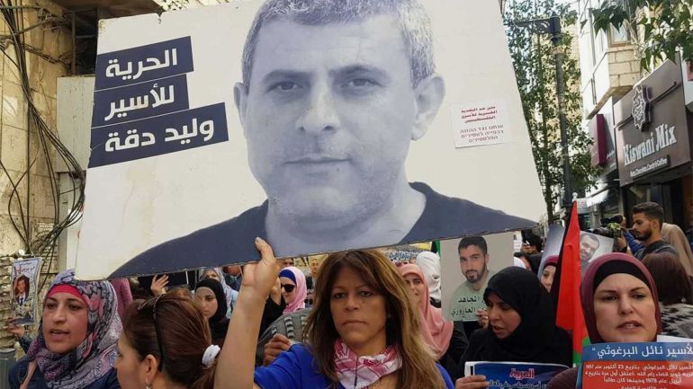 ميرفت صادق فلسطين رام الله 9 أبريل 2019 زوجة الأسير وليد دقة تحمل صورته في مسيرة لدعم إضراب الأسرى الثلاثاء وسط رام الله قبل يوم من نقله إلى العزل.psd