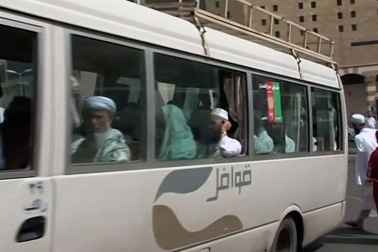 BUS CARRYING AFGHAN PILGRIMS ARRIVING, BUS WITH AFGHAN PILGRIMS DRIVING THROUGH PARKING LOT, VARIOUS OF AFGHAN PILGRIMS GETTING OFF BUS