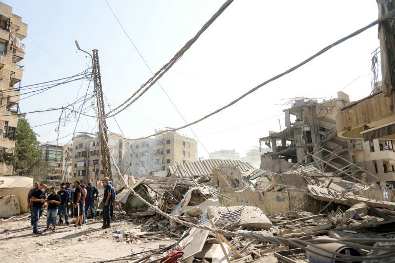 People stand by the rubble of a collapsed building at the site of an overnight Israeli airstrike in the Hadath neighbourhood of Beirut’s southern suburbs on June 6, 2025.