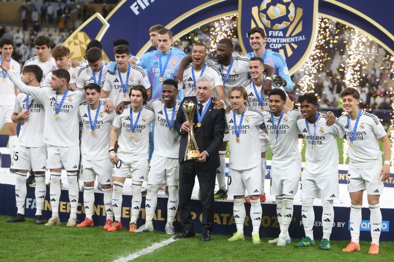 Real Madrid's players pose with the trophy after winning the Intercontinental Cup soccer final match against CF Pachuca at the Lusail Stadium in Lusail, Qatar, Wednesday, Dec. 18, 2024. Real Madrid won the game 3-0.(AP Photo/Hussein Sayed)