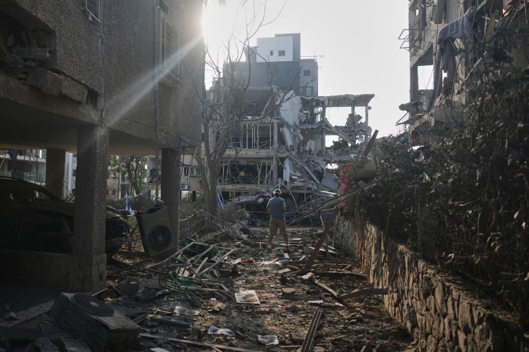 People look at a destroyed residential building that was hit by a missile fired from Iran, in Ramat Gan, near Tel Aviv, Israel on Saturday, June 14, 2025. (AP Photo/Ariel Schalit)