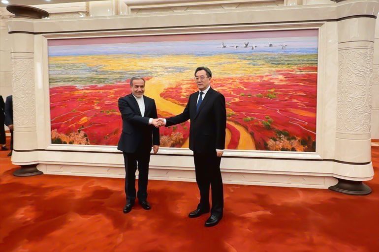 In this photo released by Iranian Foreign Ministry, Iranian Foreign Minister Abbas Araghchi, left, shakes hands with China's Vice Prime Minister Ding Xuexiang during their meeting in Beijing, China, Wednesday, April 23, 2025. (Iranian Foreign Ministry via AP)