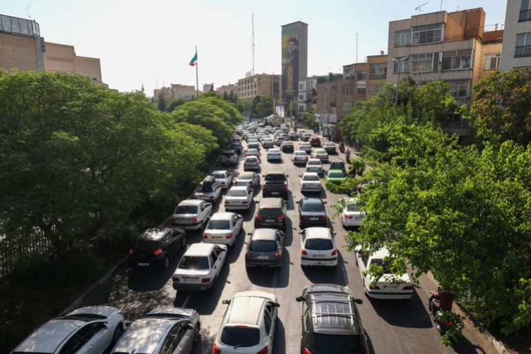 Vehicles await in traffic as people get out of Tehran through an artery in the city's west on June 15, 2025. Iranian media said an Israeli strike hit the Tehran police headquarters in the city centre on June 15, as the two foes exchanged fire for a third day. (Photo by Atta KENARE / AFP)