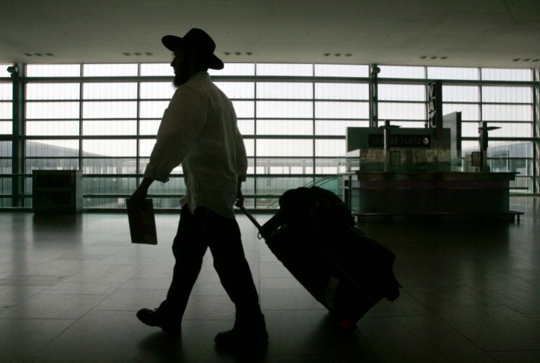 A lone traveller walks with his luggage through Ben-Gurion international airport near Tel Aviv March 21, 2007. Israel's powerful Histadrut labour union launched a general strike on Wednesday, stopping international flights and shutting public services after talks with the government broke down. The open-ended strike began at 9 a.m. (0700 GMT) but a labour court was due to convene to discuss a government petition for a restraining order to restore services. Israel Radio said the court was expected to rule within hours. REUTERS/Yonathan Weitzman (ISRAEL)