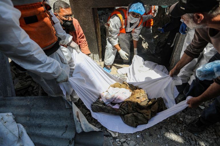 KHAN YUNIS, GAZA - APRIL 13: (Editors note: Image contains graphic detail) Members of the Palestinian Civil Defense retrieve the remains of Palestinian citizens from under the rubble of homes destroyed during Israeli air strikes, on April 13, 2024 in Khan Yunis, Gaza. The Israeli military has scaled back ground troops in the southern Gaza Strip, leaving only one brigade. However Israeli officials have vowed to launch a ground invasion of Rafah at a later date.(Photo by Ahmad Hasaballah/Getty Images)