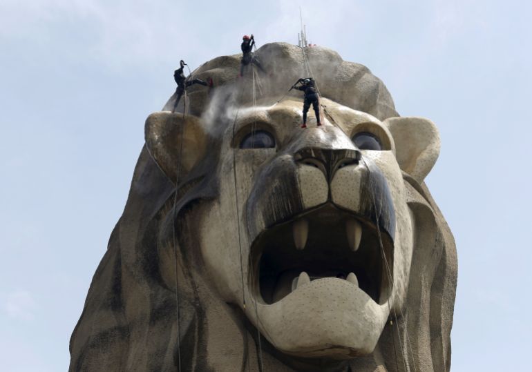 Cleaners spray clean the 37-meter tall tourism icon of the Merlion on the resort island of Sentosa ahead of the city-state's 50th anniversary celebrations in Singapore July 8, 2015. The five day long cleaning is the mythical creature's first