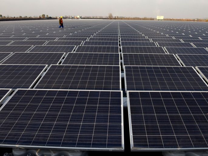 A worker walks among solar panels at a floating solar plant developed by China's Three Gorges Group, in Huainan, Anhui province, China December 11, 2017. Picture taken December 11, 2017. REUTERS/Stringer ATTENTION EDITORS - THIS IMAGE WAS PROVIDED BY A THIRD PARTY. CHINA OUT. TPX IMAGES OF THE DAY