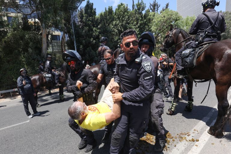 Members of the Israeli security forces arrest a demonstrator, during an anti-government protest demanding a deal to release Israelis detained in the Gaza Strip by Hamas militants since October 7, 2023, in Tel Aviv on August 17, 2025