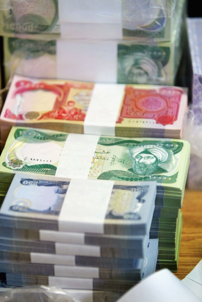 TIKRIT, IRAQ - OCTOBER 15: New Iraqi dinars sit in a bank on October 15, 2003 in Tikrit, Iraq. Today is the first day of exchanging old Iraqi dinars for new currency without Saddam Hussein''s image on, available in six denominations - 50, 250, 1,000, 5,000 and 25,000 . (Photo by Joe Raedle/Getty Images)