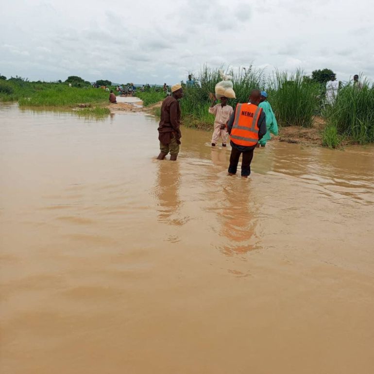 A member of the National Emergency Management Agency stands in water as search and rescue operations continues following a boat accident, in a place given as Sokoto State, Nigeria, in this handout image relased on August 17, 2025. National Emergency Management Agency, Nigeria/Handout