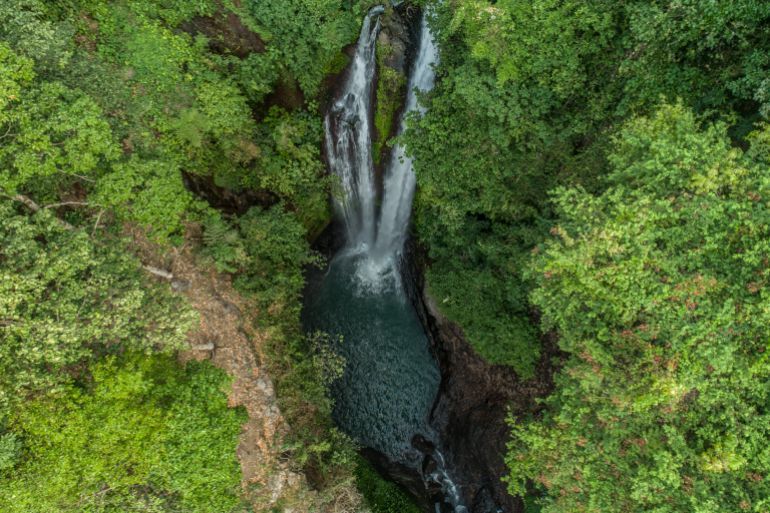 Jungle waterfall cascade in tropical rainforest with rock and turquoise blue pond. Its name Banyumala because its twin waterfall in mountain slope; Shutterstock ID 1015564531; purchase_order: ajnet; job: ; client: ; other: بالي